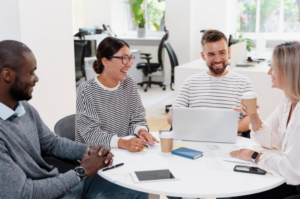 Des collègues collaborant autour d'une table, illustrant l'efficacité des apps de communication interne.